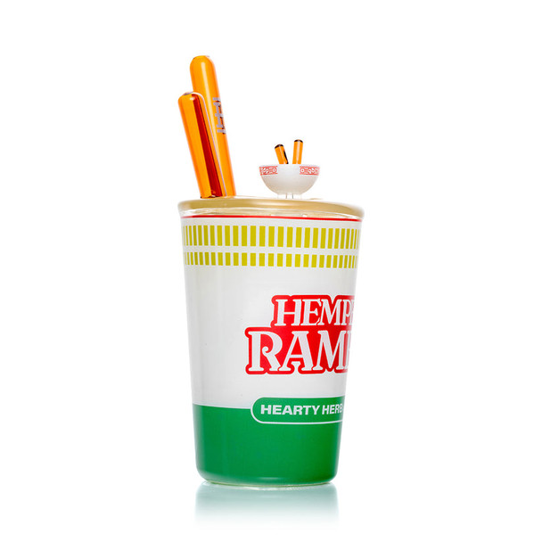 Side angle of Hemper Ramen Cup XL bong showing Hearty Herb logo wrap, textured noodle lid and amber chopstick mouthpiece, detailed view for head-shop buyers.