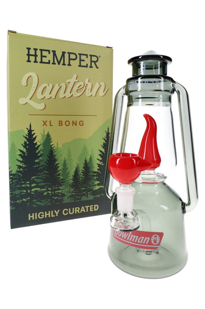 Hemper Bowlman Lantern XL bong in smoke glass posed beside green forest “Hemper Lantern XL Bong” box, camp-style water pipe display shot for head-shop buyers.