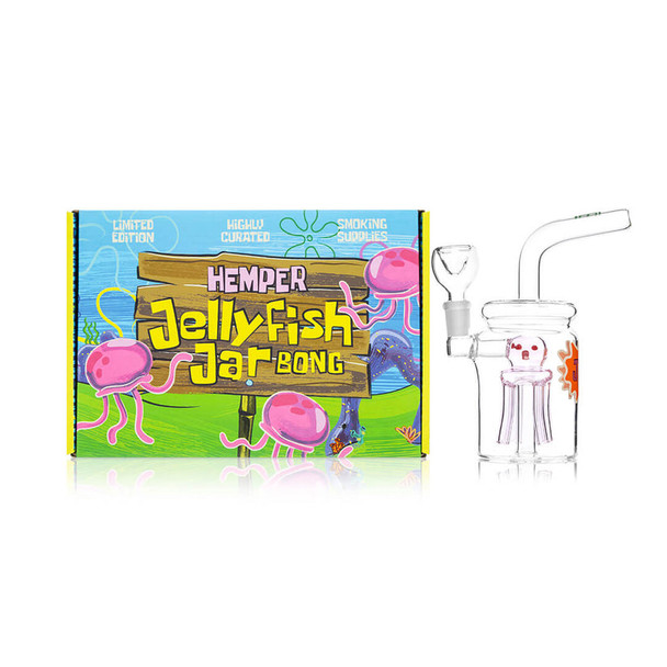 Pink-perc Hemper Jellyfish Jar bong displayed next to bright cartoon Jellyfish Jar Bong packaging, hero image for online smoke shop wholesale catalogs.