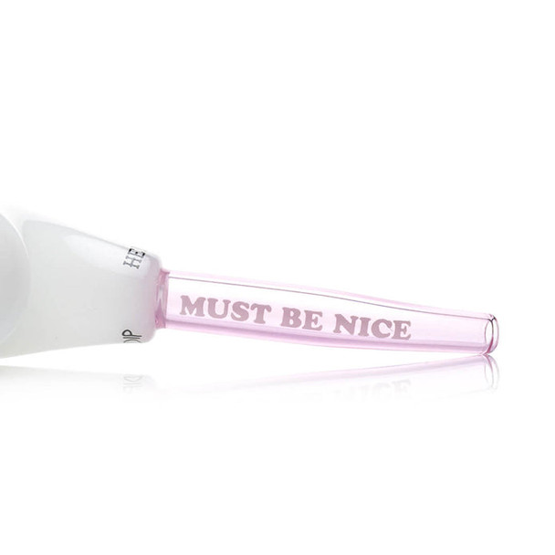 Pink-tinted mouthpiece close-up with “MUST BE NICE” text on glass, wholesale hand pipe detail shot for shops