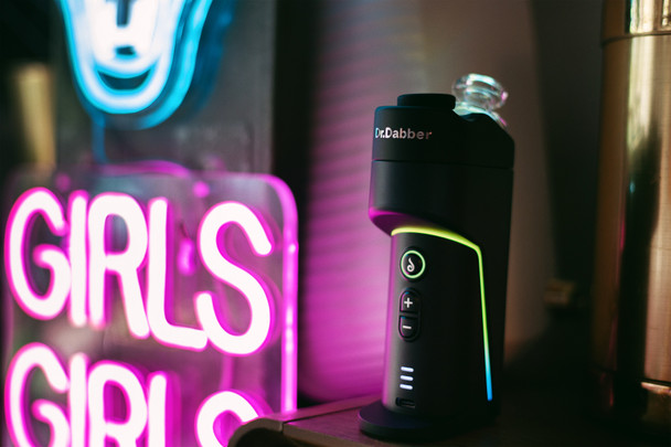 Dr. Dabber Switch GO standing on a shelf with glowing accent lights and visible front controls
