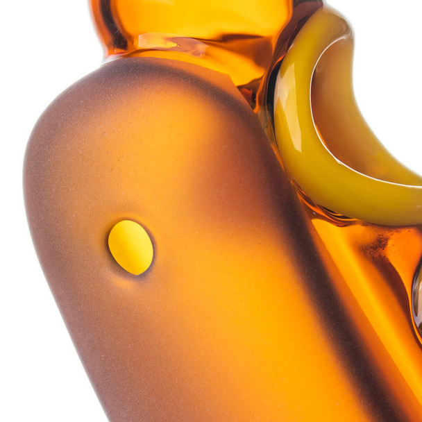 Close-up of Glizzy hand pipe side carb set into the frosted amber-orange glass body