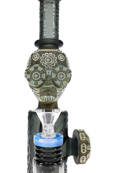 Close-up of stone alien head with gear-like geometric details and clear bowl on frosted glass water pipe