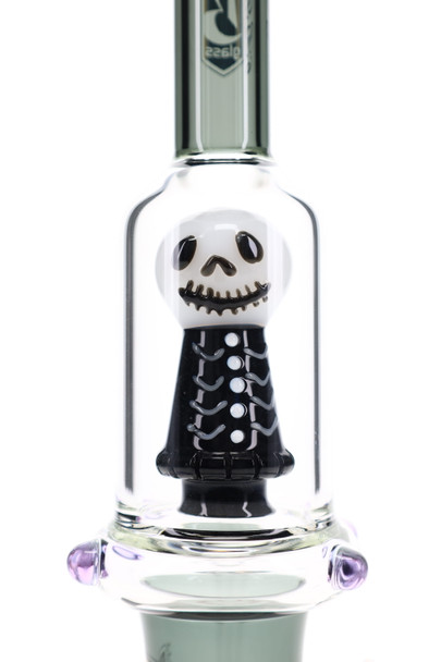 Close-up of 6B Glass skull showerhead perc with black skeleton body inside clear glass for head-shop displays.
