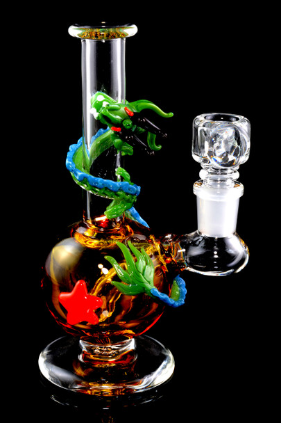 Amber sphere-body mini rig with green dragon wrap and 14.5 mm female joint on black—premium wholesale concentrate rig, 6.5" clear borosilicate.
