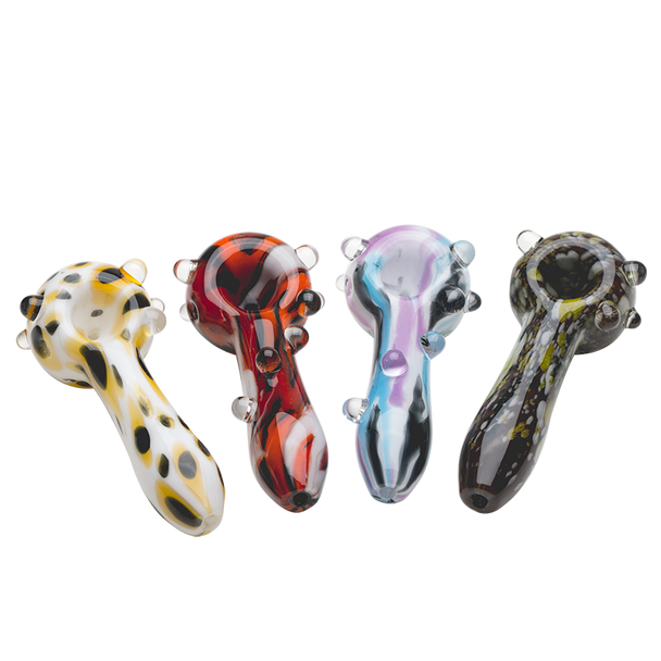 Front lineup of four 4" psychedelic spoon pipes on white, assorted colorways with clear marble grips—retail smoke-shop wholesale image showing bowls and stems.
