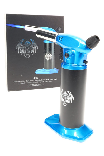 Blue Special Blue Toro butane torch for bulk purchasing, black tank and wide base, front-left angle beside retail box, jet nozzle extended. Blue Special Blue Toro butane torch for bulk purchasing, black tank and wide base, front-left angle beside retail box, jet nozzle extended.