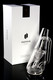 Clear borosilicate Ryan Fitt recycler glass beside Puffco Peak retail box, three-quarter angle—wholesale head-shop upgrade piece.