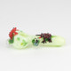 Side profile for wholesale catalogs showing small Ribbit spoon pipe, pale-green glass with frogs and lily-pad detail, clean studio white.