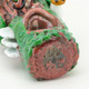 Close macro of mushroom appliqués and moss detail on log pipe; novelty head-shop accessory image for B2B product pages.