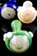Trio of 5" honeycomb-bowl spoon pipes for wholesale head shops, green, blue, and fumed beige glass with marble grips, close-up bowl detail on black.
