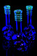 Wholesale 10.5-inch metallic skull soft glass water pipes with glow-dark swirl necks, trio black-light front view.