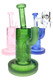 Assorted pink, green, and blue wholesale dab rigs with frosted biotech graphics and compact stemless bodies.