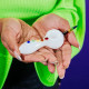 Person holding white unicorn glass hand pipe with rainbow horn mouthpiece and raised color dots