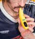 Yellow Ooze Peel banana battery held near mouth with digital screen and Ooze logo visible
