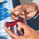 Lifestyle image of red Ooze Hinge Flick battery holding a 510 cartridge in open position during use
