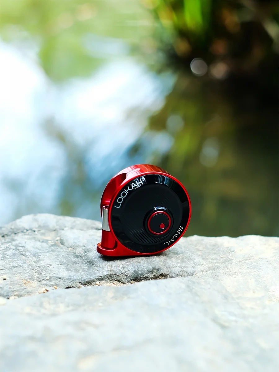 Lookah Snail 2.0 red compact 510 battery standing on a rock; round shell profile with single button