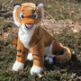 Auswella Plush Kenya realistic tiger stuffed animal with orange and black stripes, white chest and paws, posed outdoors in a lush jungle-inspired setting
