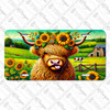 Highland cow with sunflowers license plate featuring long-haired cow wearing sunflower crown in a rustic barnyard and pasture setting.