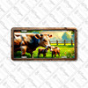 Farm cow with calves license plate featuring mother cow and two calves in a rustic barnyard pasture with wooden fence and lush greenery.