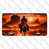 Western cowboy sunset license plate featuring shadowed cowboy on horseback riding through desert canyon with mesas and cacti in fiery orange tones.