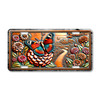 License plate featuring a colorful butterfly perched on a zinnia flower, surrounded by blooming garden flowers and a rustic pathway.