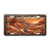 Desert Southwest mesa sunset landscape aluminum license plate featuring red rock formations, saguaro cacti, and glowing Western desert sky artwork.