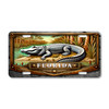 Florida alligator Everglades marsh license plate featuring detailed gator artwork resting beside swamp water with cypress trees and wetland grasses on aluminum plate.