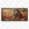 Lion license plate featuring rustic African savanna scene with acacia trees and majestic lion in embossed-look artwork on aluminum.