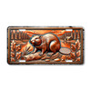 Beaver license plate featuring rustic embossed-look artwork of a beaver on a log near a river with lodge and pine forest in bronze and copper tones.