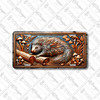 Porcupine license plate featuring rustic embossed-look artwork of a porcupine resting on logs, surrounded by mushrooms and woodland foliage in bronze and silver tones.