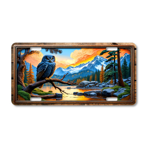 Rustic owl license plate with blue owl perched on a branch, mountain sunset, reflective lake, and carved-wood style frame on aluminum.