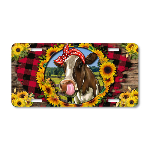 Farm cow with sunflowers license plate featuring playful cow with red headscarf framed by sunflowers, buffalo plaid, and rustic wood background.