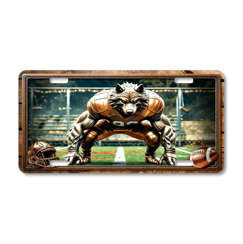 Wolf football mascot license plate featuring a crouched wolf in bronze football armor at the scrimmage line with chain-link field fence background, rustic embossed-look artwork on aluminum.