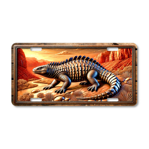 Gila Monster license plate featuring rustic desert canyon artwork in bronze and copper tones with detailed reptile scale textures on aluminum.