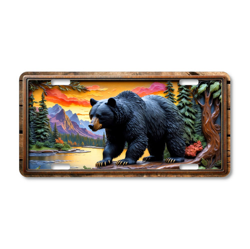 Black Bear license plate featuring rustic river sunset artwork with glowing skies, pine forest, and mountain peaks in embossed-look style on aluminum.
