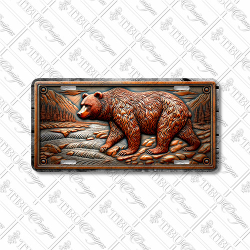 Grizzly Bear license plate featuring rustic mountain stream scene with rocky terrain, pine forest, and bronze tones in embossed-look artwork on aluminum.