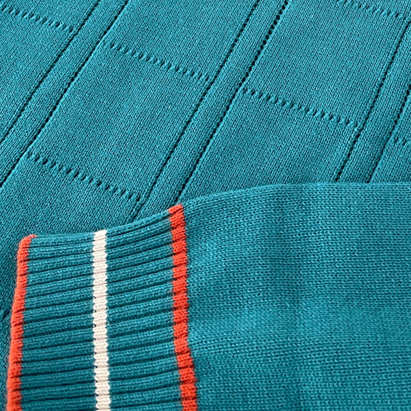 Close up on cuff on the Moore Madcap England Pointelle Knit Retro Mock Turtleneck Jumper in Gulf Coast Close up on cuff on the Moore Madcap England Pointelle Knit Retro Mock Turtleneck Jumper in Gulf Coast