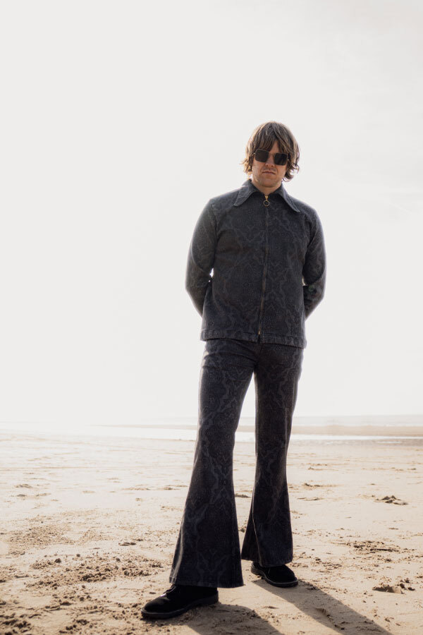 Man wears Madcap England matching Daggar Collar Zip Shirt and Paisley print bell bottom flares