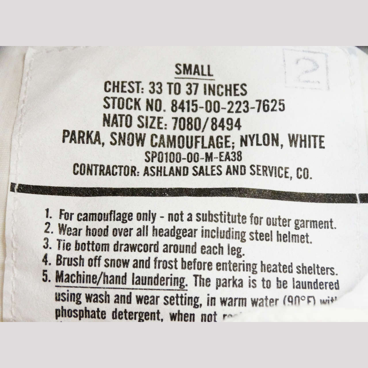 100&percnt; Genuine US Military Surplus tag for size Small, Nylon, manufactured by Ashland Sales and Service.