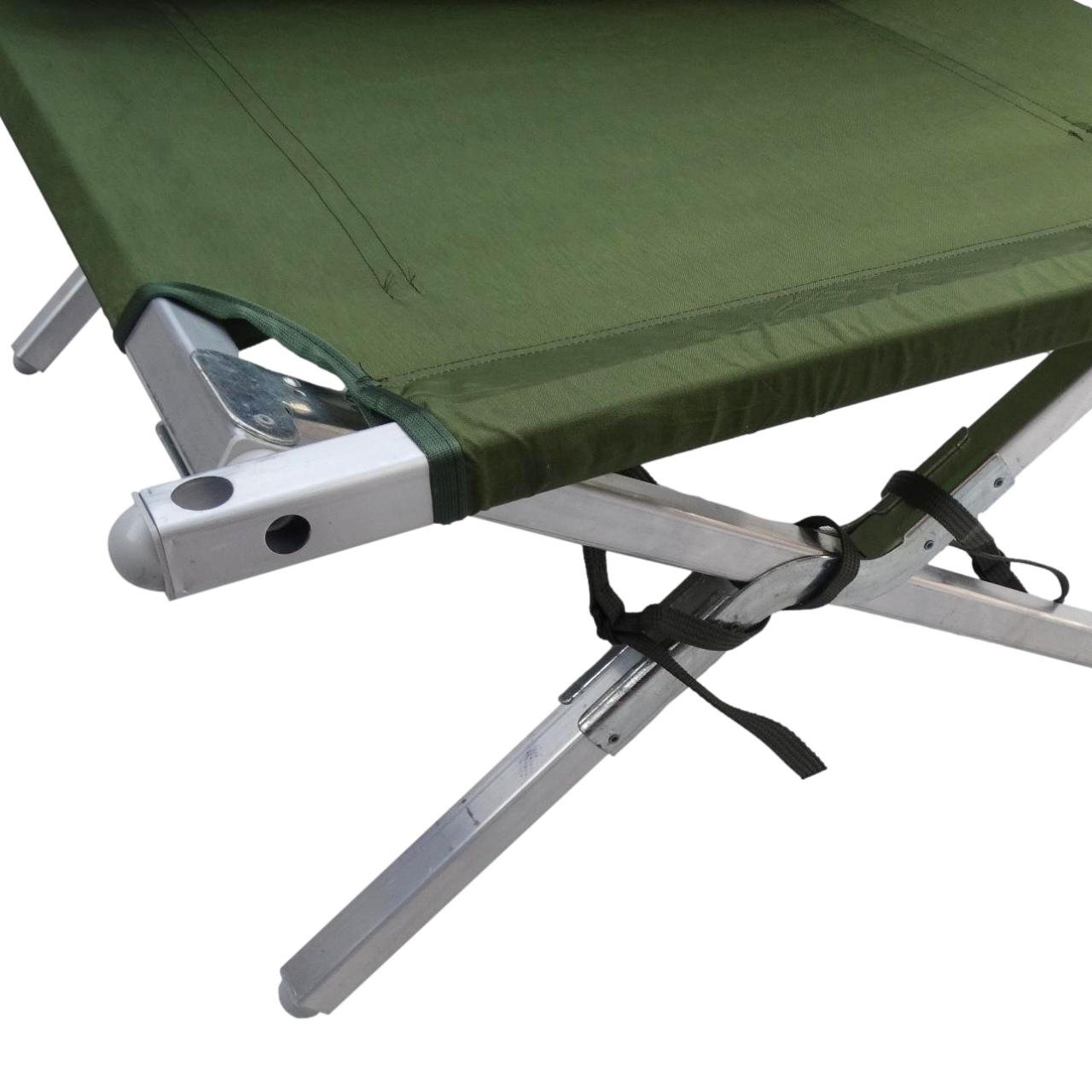 Close-up detail of military cot corner showing aluminum frame connection points, reinforced fabric edge stitching, and black support straps on olive green canvas