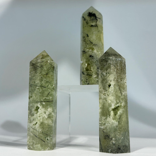 Three milky green prehnite points with dark inclusions