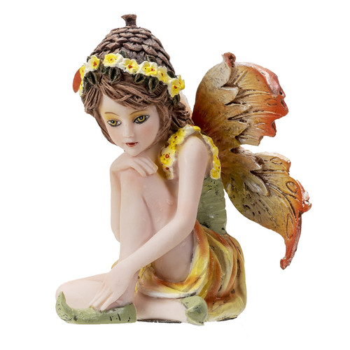 Small fairy statue with yellow flower crown, long brown hair, and orange-brown wings, sitting in a thoughtful pose, wearing a green and yellow dress.