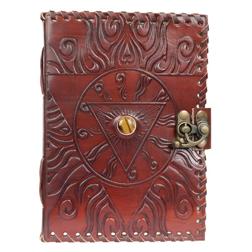 A dark brown leather journal, intricately embossed with a large evil eye design at its center, featuring a striking tiger's eye gemstone as the iris. The journal has decorative swirling patterns around the eye and a metal clasp lock system on the right side. A dark brown leather journal, intricately embossed with a large evil eye design at its center, featuring a striking tiger's eye gemstone as the iris. The journal has decorative swirling patterns around the eye and a metal clasp lock system on the right side.