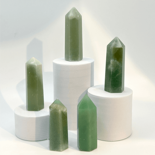 Five green aventurine crystal towers showing natural striations and speckles