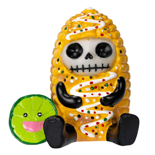 A small, whimsical figurine featuring a skeleton character wearing a bright yellow corn-on-the-cob costume. The corn costume is drizzled with white icing or sauce and speckled with red, white, and green sprinkles, resembling an elote (Mexican street corn).
