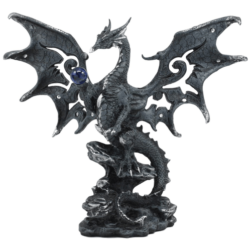 A detailed gothic dragon figurine made of dark gray and black resin with a cracked-stone texture. The dragon stands tall on a rocky base with its large, ornate wings spread wide, featuring cutout scrollwork patterns. It holds a translucent deep blue crystal ball in its right claw. Subtle silver highlights accent the dragon's scales, horns, and the tips of its wings.