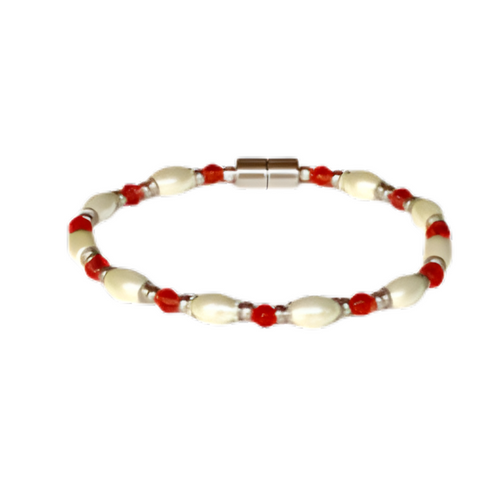 A timeless single-strand pearl bracelet featuring lustrous oval-shaped freshwater pearls and small, vibrant red bead accents, completed with a secure, polished silver magnetic clasp