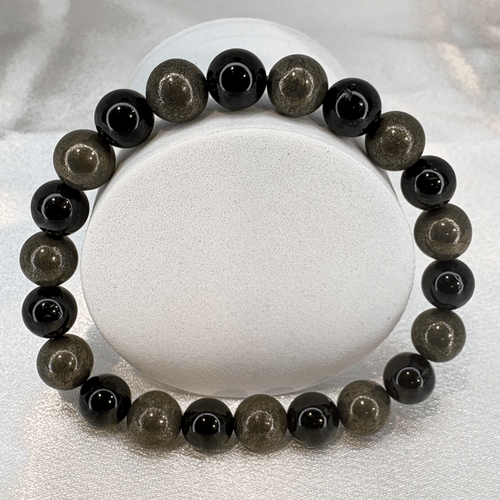 Tourmaline & Pyrite Gemstone Bracelet with polished black tourmaline and pyrite beads displayed in a circular arrangement on a white background.