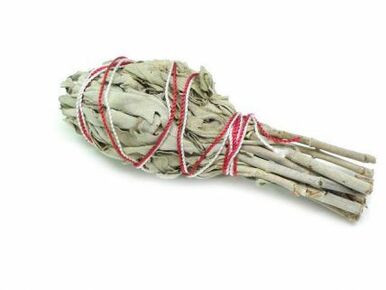 A three-inch bundle of dried white sage wrapped in red and white twine.